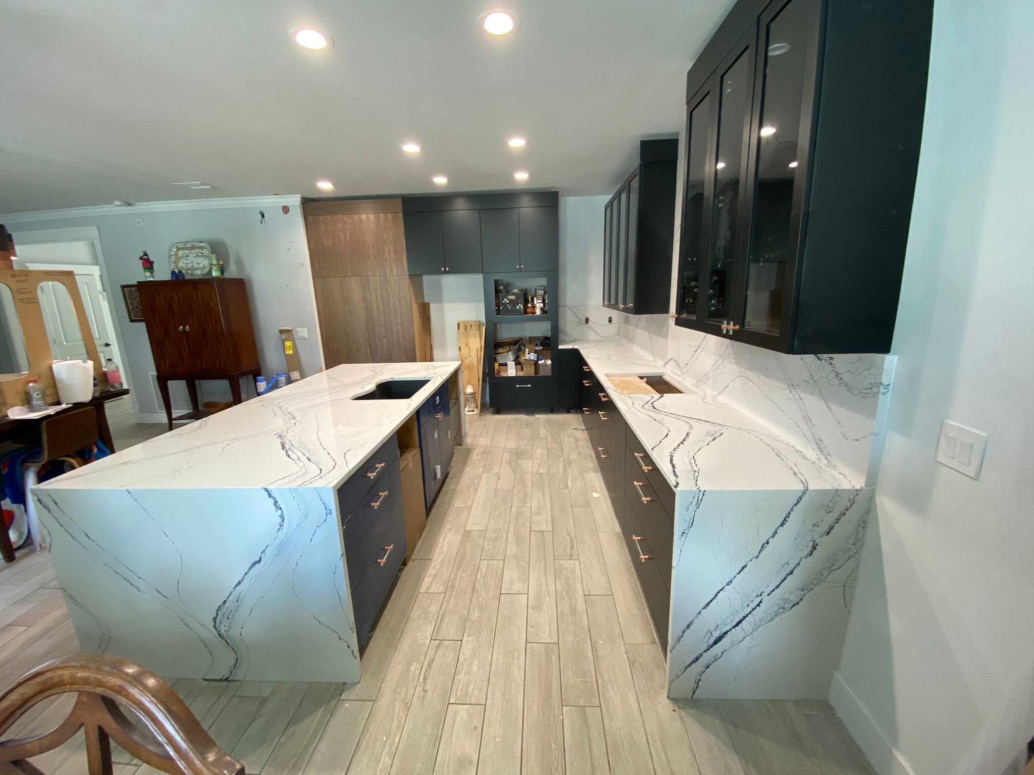Galley kitchen with dark cabinets and white stone countertops