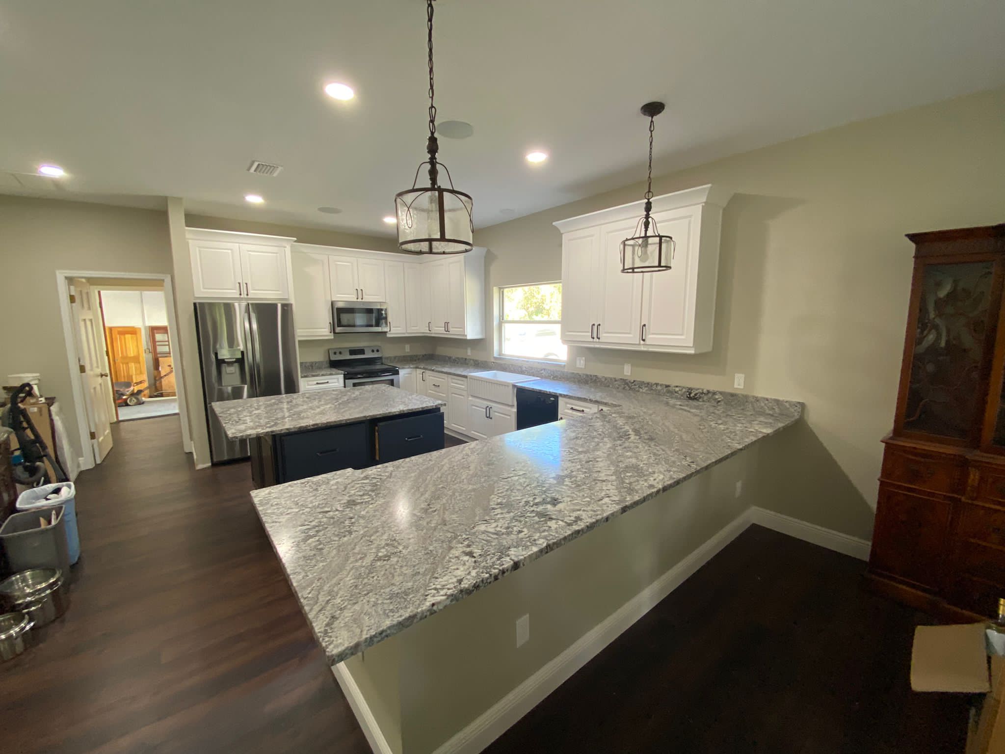 Transitional kitchen with white cabinets and navy island